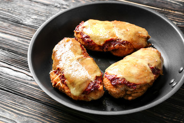 Tasty chicken parmesan with cheese on frying pan, closeup