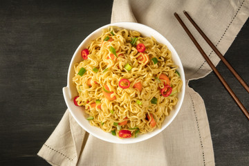Instant noodles with vegetables, chopsticks, and copy space