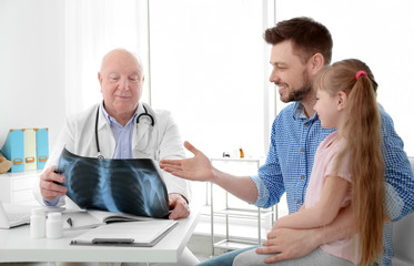 Obraz premium Little girl with father at orthopedist's office