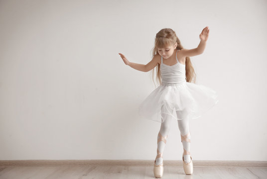 Beautiful little ballerina in light dance studio