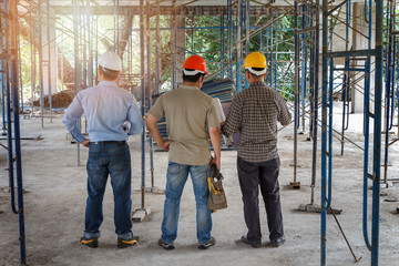 Engineer, foreman and worker discussing in building construction site