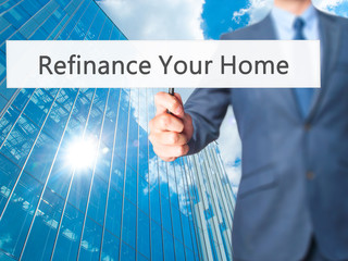 Refinance Your Home - Businessman hand holding sign