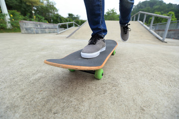 young skateboarder legs practicing at skatepark