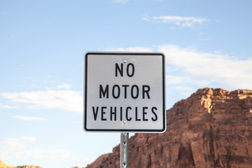 A black and white no motor vehicles sign