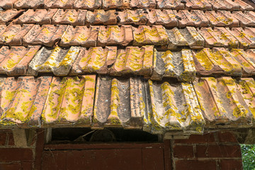 Ceramic tiles on roof of old hut with tin chimney