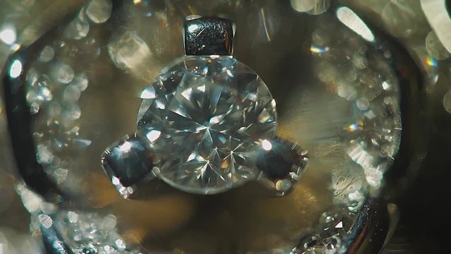 Diamond solitaire ring closeup in dark environment. Big blue diamond, closeup view. layered triangular macro diamond shapes with a small diamond over them. Round gemstone on Black Background with