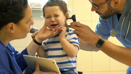 Mother with child visiting hospital, male doctor examining child's ear
- Powered by Adobe