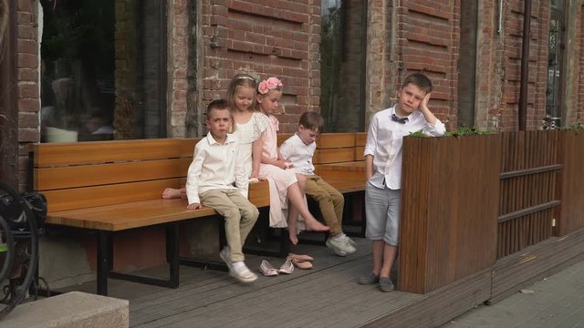 Children in beautiful of a retro to clothes on a bench in front of the camera