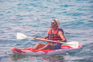 Portrait of young man paddling a kayak on summer day