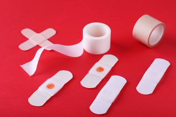 Medical plasters on red background