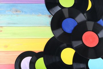 Vinyl records on colourful wooden table