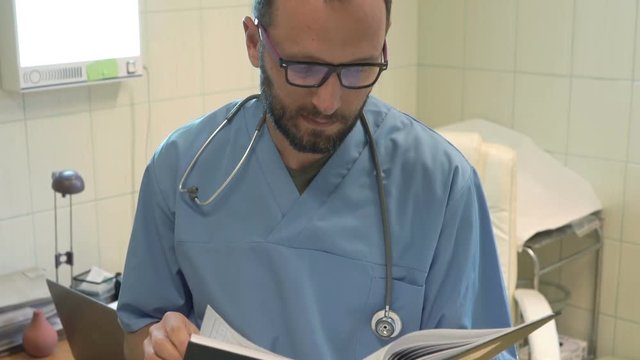 Young, male doctor working with documents in office
