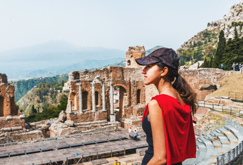 Young woman standing viewing the Greek theatre - obrazy, fototapety, plakaty