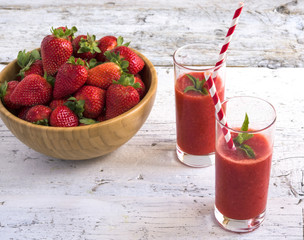 Strawberry smoothie on rustic white wooden background