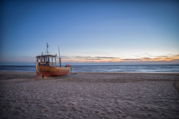 Fischerboot am Strand im Sonnenaufgang