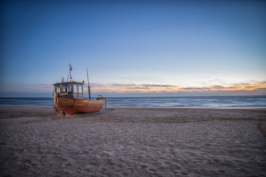 Fischerboot am Strand im Sonnenaufgang