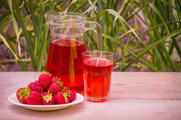 glass with strawberry juice and berries isolated on blur background
