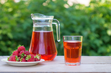 glass with strawberry juice and berries isolated on blur background