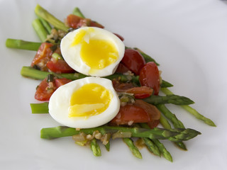 Green asparagus with a spicy vegetable sauce and boiled egg - breakfast for health