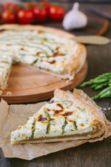 Piece of delicious asparagus pie on list of parchment.