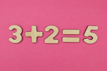 Simple arithmetic for children. Three plus two - equal to five on a bright pink background.