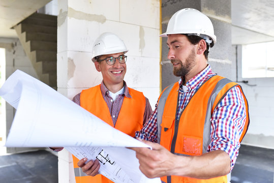 Bauleiter und Architekt vor Ort beim Neubau eines Hauses im Rohbau