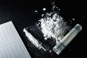 Cocaine tracks and a card on a black background