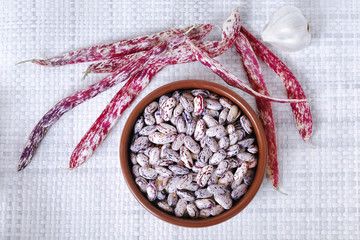Uncooked beans. Bowl full of raw beans, on white background. View from above.