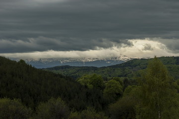 Beautiful landscape of spring nature with green glade and forest in  Plana mountain tovard Rila mountain, Bulgaria  