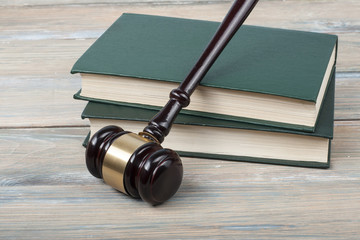 Law concept - wooden judges gavel on table in a courtroom or enforcement office.