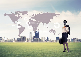 Camera headed woman standing on green grass against modern citys