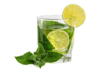 A glass with a lime and mint drink on an isolate against a white background