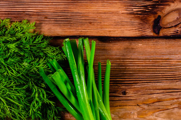 Green dill and onion on wooden table. Top view