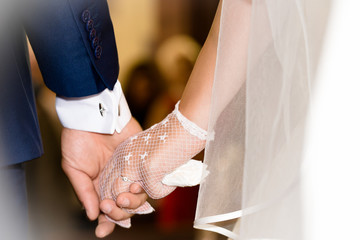 Bride and groom holding hands during wedding ceremony