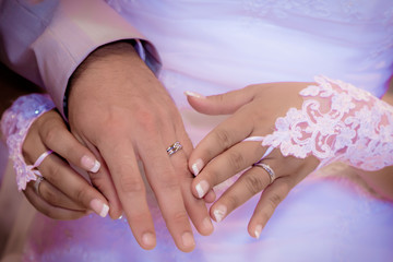 Close up hands of bride and groom putting on a wedding rings