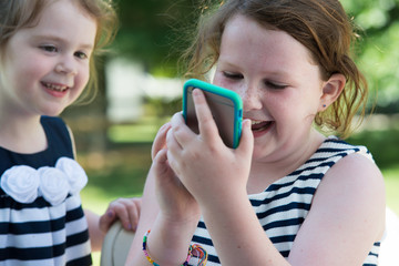 Happy Laughing Children Playing with Smartphone Outside