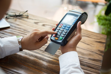 Unrecognizable businessman spending money in cafe