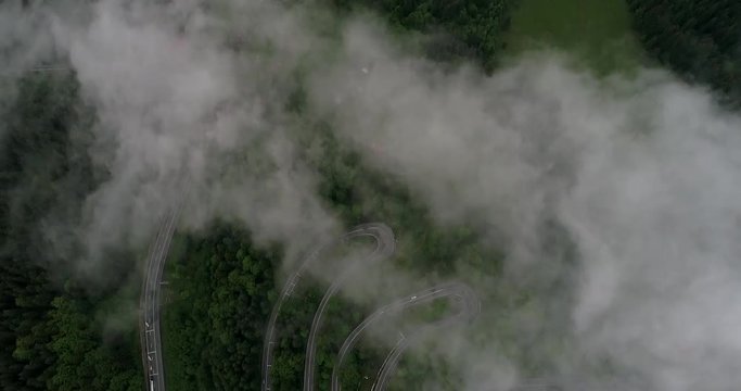 Aerial video of Romanian Carpathians with winding road and thick green forest - 50fps