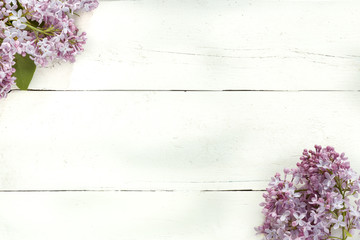 Bouquet of lilac flowers on white wooden background.