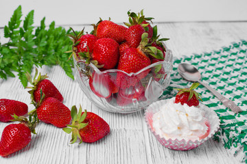 Summer dessert: strawberries and cream on a wooden table