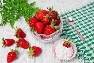 Summer dessert: strawberries and cream on a wooden table