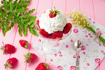 Summer dessert: strawberries and cream on a wooden table