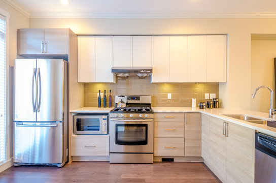 Modern, bright, clean, kitchen interior with stainless steel appliances in a luxury house.
