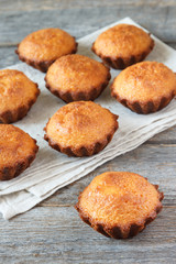A few muffins in the baking dish. Wooden background.