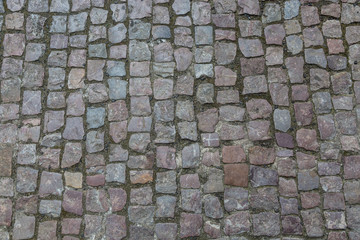 Granite cobblestoned pavement background. Stone pavement texture. Abstract background of old cobblestone pavement close-up in Prague