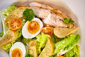 Chicken salad with leaf vegetables, chard, eggs, bulgur and cherry tomatoes. Chicken Caesar Salad. Caesar Salad with grilled chicken on plate. Grilled chicken breasts and fresh salad in plate.