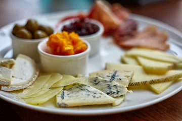 Cheese plate with different kinds of cheese with thyme herbs and walnuts. Mix cheese on wooden board with grapes. Top view..