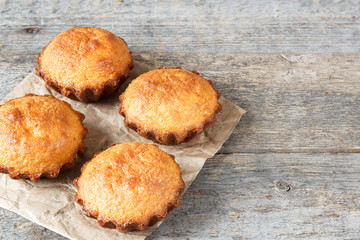 A few muffins in the baking dish. Wooden background.