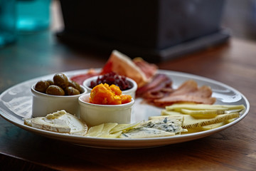 Cheese plate with different kinds of cheese with thyme herbs and walnuts. Mix cheese on wooden board with grapes. Top view..
