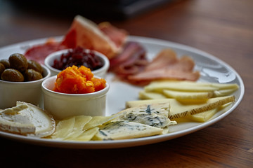 Cheese plate with different kinds of cheese with thyme herbs and walnuts. Mix cheese on wooden board with grapes. Top view..